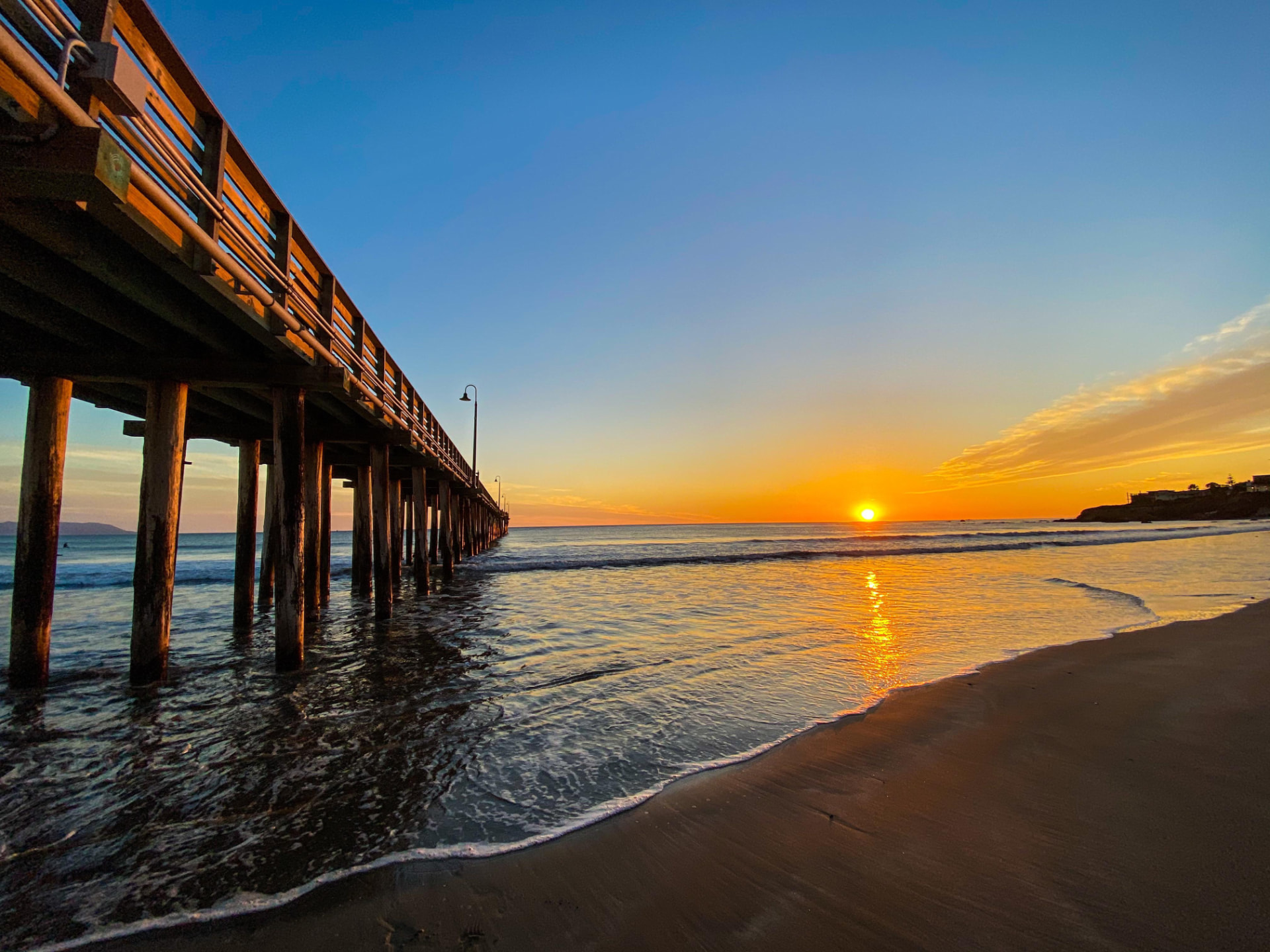 The Cayucos Pier stretching out over the Pacific Ocean at sunset